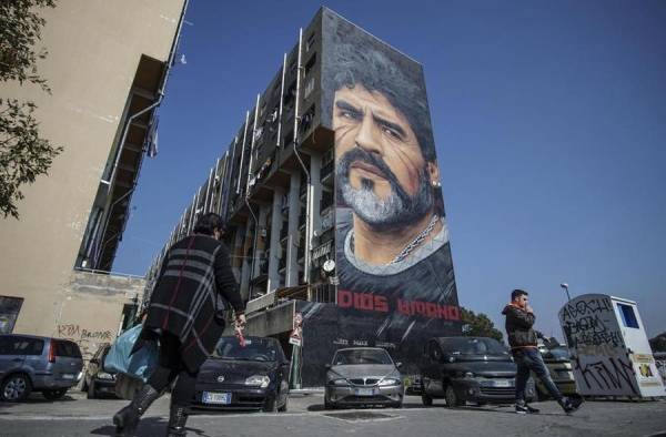Mural con la imagen del exfutbolista argentino Diego Armando Maradona, realizado por el artista italiano Jorit Agoch, en un edificio del barrio San Giovanni a Teduccio, en Nápoles. Mural con la imagen del exfutbolista argentino Diego Armando Maradona, realizado por el artista italiano Jorit Agoch, en un edificio del barrio San Giovanni a Teduccio, en Nápoles.