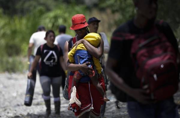 Una mujer migrante carga a su hijo en la selva Una mujer migrante carga a su hijo en la selva