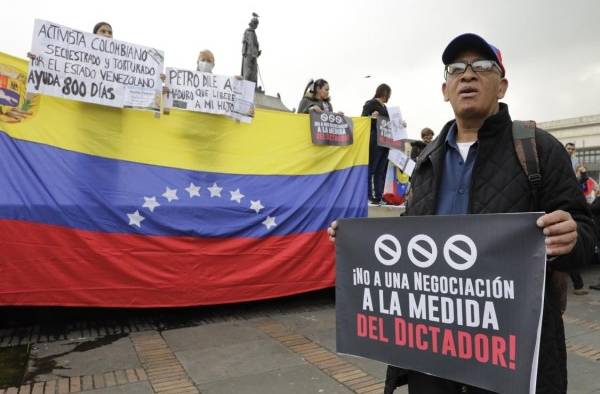 Con banderas y pancartas, un grupo de venezolanos residentes en Colombia participa hoy de una protesta en la Plaza de Bolívar de Bogotá (Colombia). Con banderas y pancartas, un grupo de venezolanos residentes en Colombia participa hoy de una protesta en la Plaza de Bolívar de Bogotá (Colombia).