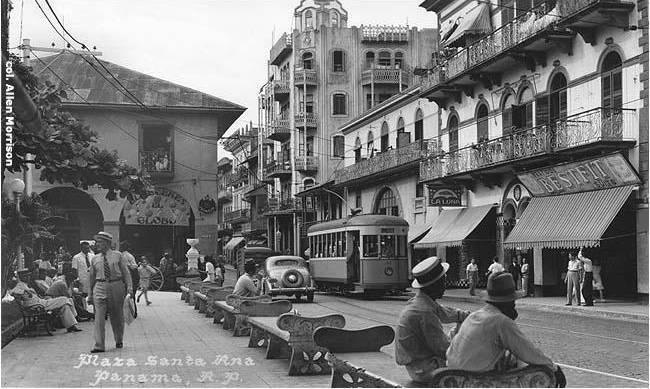 El tranvía viaja por la Avenida Central en dirección a Calidonia. En primer plano, transeúntes en la Plaza de Santa Ana (1913).