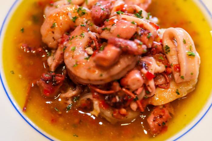El salpicón de mariscos es parte de las tapas frías del menú y se forma de un mixto de pulpo, calamares y gambas macerados en pimentón, cebolla, vinagre y aceite de oliva extra virgen. El salpicón de mariscos es parte de las tapas frías del menú y se forma de un mixto de pulpo, calamares y gambas macerados en pimentón, cebolla, vinagre y aceite de oliva extra virgen.
