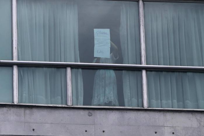 Una persona sostiene un cartel desde una ventana de un hotel este martes 18 de febrero de 2025 en Ciudad de Panamá. Una persona sostiene un cartel desde una ventana de un hotel este martes 18 de febrero de 2025 en Ciudad de Panamá.