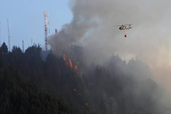 Un helicóptero combate hoy un incendio forestal en el cerro El Cable, en Bogotá (Colombia). Un helicóptero combate hoy un incendio forestal en el cerro El Cable, en Bogotá (Colombia).