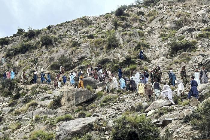 Voluntarios afganos caminan por una ladera tras el terremoto en el distrito de Nurgal, provincia de Kunar. Voluntarios afganos caminan por una ladera tras el terremoto en el distrito de Nurgal, provincia de Kunar.