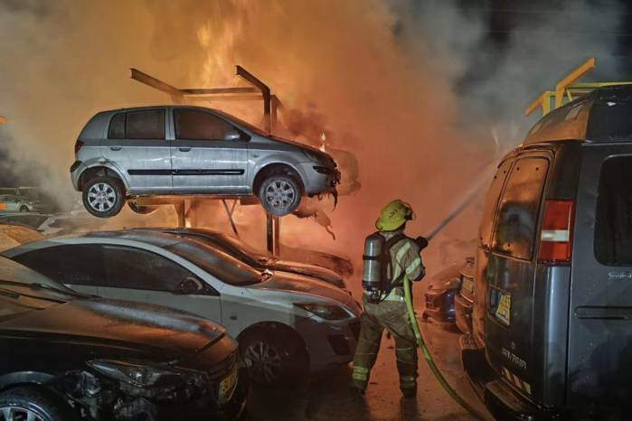 Fotografía cedida por el Cuerpo de Bomberos y Rescate de Israel que muestra a un bombero apagando un incendio en un estacionamiento este miércoles, en Distrito Central de Israel. Fotografía cedida por el Cuerpo de Bomberos y Rescate de Israel que muestra a un bombero apagando un incendio en un estacionamiento este miércoles, en Distrito Central de Israel.