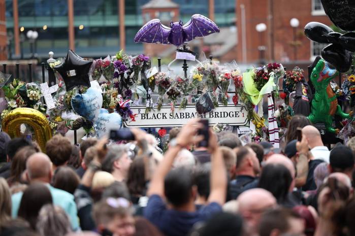 Los fanáticos toman fotos de los tributos a Ozzy Osbourne en el banco de Black Sabbath y el puente después de ver el cortejo fúnebre de Osbourne en Birmingham. Los fanáticos toman fotos de los tributos a Ozzy Osbourne en el banco de Black Sabbath y el puente después de ver el cortejo fúnebre de Osbourne en Birmingham.
