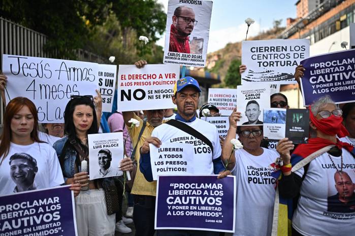 Familiares de presos políticos sostienen pancartas mientras participan en una vigilia exigiendo su liberación frente a la sede del Servicio Bolivariano de Inteligencia Nacional (SEBIN), conocida como El Helicoide, en Caracas, el 10 de abril de 2025. Familiares de presos políticos sostienen pancartas mientras participan en una vigilia exigiendo su liberación frente a la sede del Servicio Bolivariano de Inteligencia Nacional (SEBIN), conocida como El Helicoide, en Caracas, el 10 de abril de 2025.