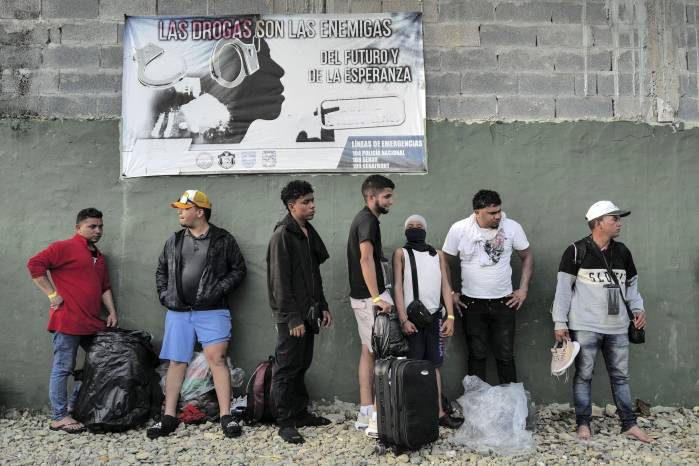 Los migrantes venezolanos esperan en fila para ser revisados por la policía fronteriza panameña en un muelle en la ciudad de Puerto Obaldía, Panamá. Los migrantes venezolanos esperan en fila para ser revisados por la policía fronteriza panameña en un muelle en la ciudad de Puerto Obaldía, Panamá.