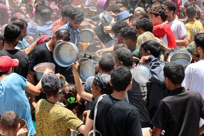Palestinos intentan conseguir comida en un comedor social que ofrece comidas calientes en el barrio de Rimal, en la ciudad de Gaza, el 18 de junio de 2025. Palestinos intentan conseguir comida en un comedor social que ofrece comidas calientes en el barrio de Rimal, en la ciudad de Gaza, el 18 de junio de 2025.