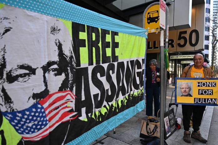 Supporters of WikiLeaks founder Julian Assange hold banners and placards as they protest in support of him outside the US Consulate General in Sydney on June 26, 2024. - A US judge freed Julian Assange on June 26 in a plea deal that ends years of legal drama for the WikiLeaks founder, long wanted by Washington for revealing military secrets. Supporters of WikiLeaks founder Julian Assange hold banners and placards as they protest in support of him outside the US Consulate General in Sydney on June 26, 2024. - A US judge freed Julian Assange on June 26 in a plea deal that ends years of legal drama for the WikiLeaks founder, long wanted by Washington for revealing military secrets.