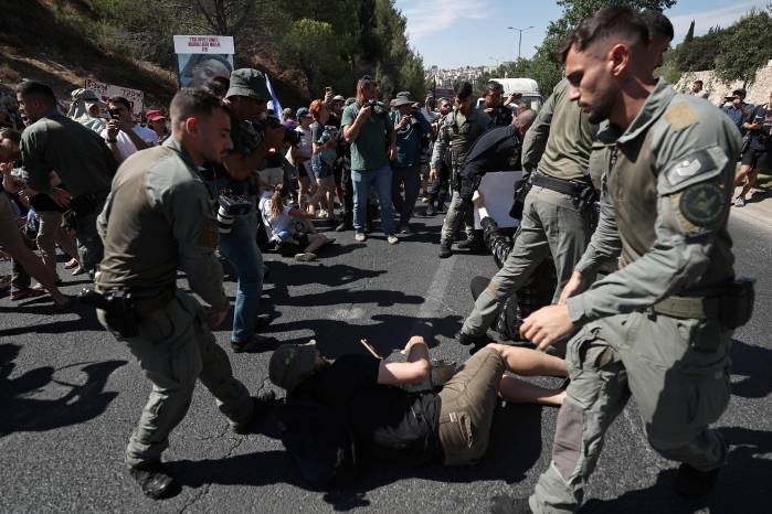 Agentes de policía israelíes intentan retirar a los manifestantes que bloquearon una carretera principal en Jerusalén. Agentes de policía israelíes intentan retirar a los manifestantes que bloquearon una carretera principal en Jerusalén.