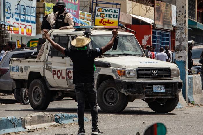 Se ve a un hombre que levanta los brazos frente a unos agentes policiales durante una protesta contra la inseguridad y la violencia en Puerto Príncipe (Haití). Se ve a un hombre que levanta los brazos frente a unos agentes policiales durante una protesta contra la inseguridad y la violencia en Puerto Príncipe (Haití).