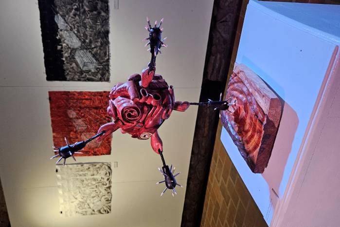‘La migración flotante’, escultura en madera. Al fondo, ‘My destiny’, ‘Destino rojo’ y ‘Destino’, acrílico tinta y alfileres sobre papel. ‘La migración flotante’, escultura en madera. Al fondo, ‘My destiny’, ‘Destino rojo’ y ‘Destino’, acrílico tinta y alfileres sobre papel.
