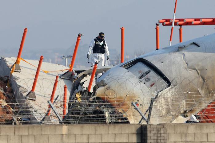 Un funcionario de un equipo de investigación científica de la Policía participa en la investigación en el lugar donde un avión se estrelló. Un funcionario de un equipo de investigación científica de la Policía participa en la investigación en el lugar donde un avión se estrelló.