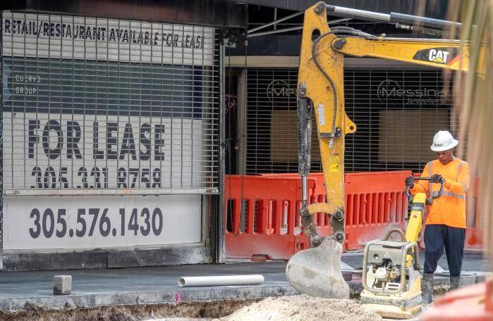 Un trabajador de la construcción trabaja frente a una tienda en el centro de Miami. Un trabajador de la construcción trabaja frente a una tienda en el centro de Miami.
