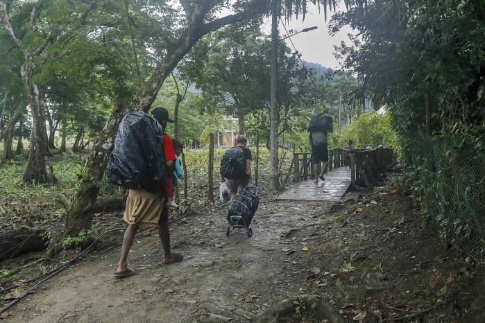 Personas caminan durante un recorrido de migrantes el 30 de agosto de 2025, en zona rural de Sapzurro. Personas caminan durante un recorrido de migrantes el 30 de agosto de 2025, en zona rural de Sapzurro.