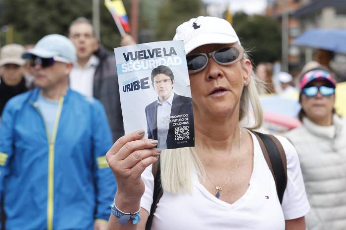 Una mujer sostiene un cartel durante una caminata por la paz y en apoyo al senador Miguel Uribe Turbay este domingo, en Bogotá (Colombia). Una mujer sostiene un cartel durante una caminata por la paz y en apoyo al senador Miguel Uribe Turbay este domingo, en Bogotá (Colombia).