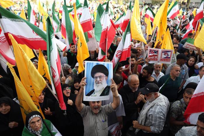 Un iraní sostiene un retrato del líder supremo, el ayatolá Alí Jamenei, entre banderas nacionales durante una manifestación en Teherán, el 24 de junio de 2025. Un iraní sostiene un retrato del líder supremo, el ayatolá Alí Jamenei, entre banderas nacionales durante una manifestación en Teherán, el 24 de junio de 2025.