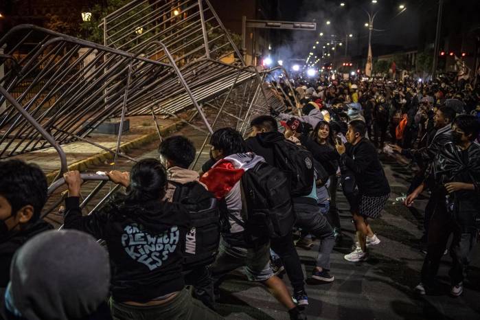 Personas tumban una valla durante una manifestación en Lima (Perú), en una fotografía de archivo. Personas tumban una valla durante una manifestación en Lima (Perú), en una fotografía de archivo.