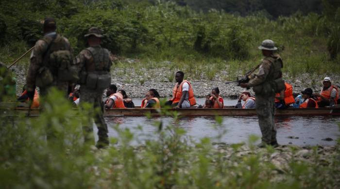 Agentes del Senafront custodian la llegada de migrantes luego de caminar por varios días la selva del Darién con rumbo a Estados Unidos.