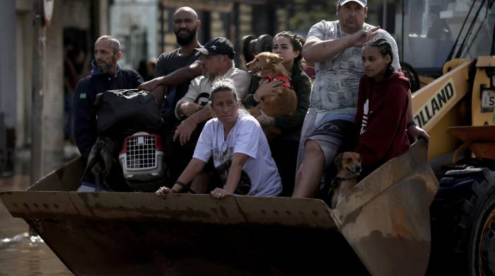 Personas son transportadas en una retroexcavadora luego de ser rescatadas en el barrio Sarandí en Porto Alegre. Personas son transportadas en una retroexcavadora luego de ser rescatadas en el barrio Sarandí en Porto Alegre.