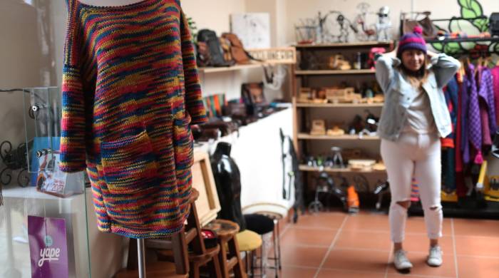 Una mujer probándose una prenda es vista al interior de una tienda que ofrece ropa confeccionada por internas de centros penitenciarios, el 6 de febrero de 2024, en La Paz (Bolivia). Una mujer probándose una prenda es vista al interior de una tienda que ofrece ropa confeccionada por internas de centros penitenciarios, el 6 de febrero de 2024, en La Paz (Bolivia).
