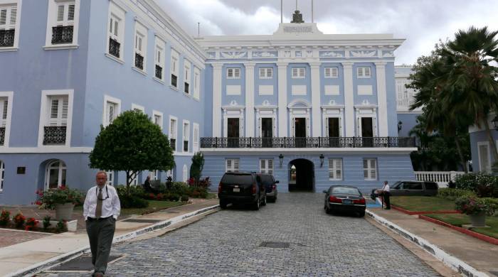 Fachada del Palacio de Santa Catalina, sede del Gobierno de Puerto Rico, con las banderas estadounidense, puertorriqueña y española.