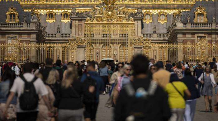 Los visitantes recorren las instalaciones frente a las puertas doradas del Palacio de Versalles, al suroeste de París, el 7 de junio de 2023. Los visitantes recorren las instalaciones frente a las puertas doradas del Palacio de Versalles, al suroeste de París, el 7 de junio de 2023.