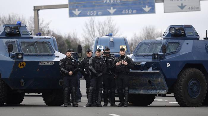 Miembros de la policía francesa y vehículos antidisbrubios en un acceso a París. Miembros de la policía francesa y vehículos antidisbrubios en un acceso a París.