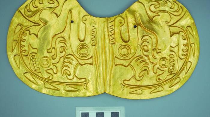 Pectoral de oro martillado en forma de mariposa, repujado con imágenes de dos ciervos y cocodrilo.