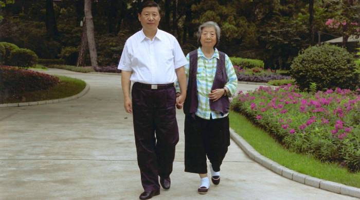 Xi Jinping pasea junto a su madre, Qi Xin. Xi Jinping pasea junto a su madre, Qi Xin.