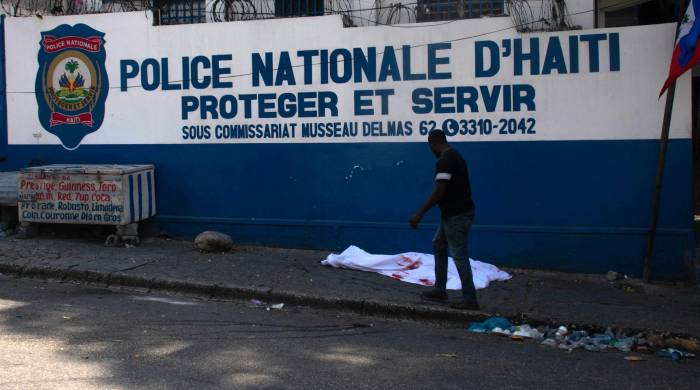 Un hombre pasa junto al cuerpo de un oficial de policía asesinado en medio de la violencia de pandillas en Puerto Príncipe, Haití. Un hombre pasa junto al cuerpo de un oficial de policía asesinado en medio de la violencia de pandillas en Puerto Príncipe, Haití.