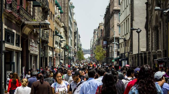 Citadinos y turistas que caminan por una avenida de la ciudad de México Citadinos y turistas que caminan por una avenida de la ciudad de México
