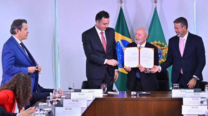 El presidente de Brasil, Luiz Inácio Lula da Silva (2-d), sostiene un documento junto del ministro de hacienda Fernando Haddad (i), el presidente del Senado Rodrigo Pacheco (2-i) y el presidente de la Cámara de Diputados Arthur Lira (d), este 6 de mayo de 2024, en Brasilia
