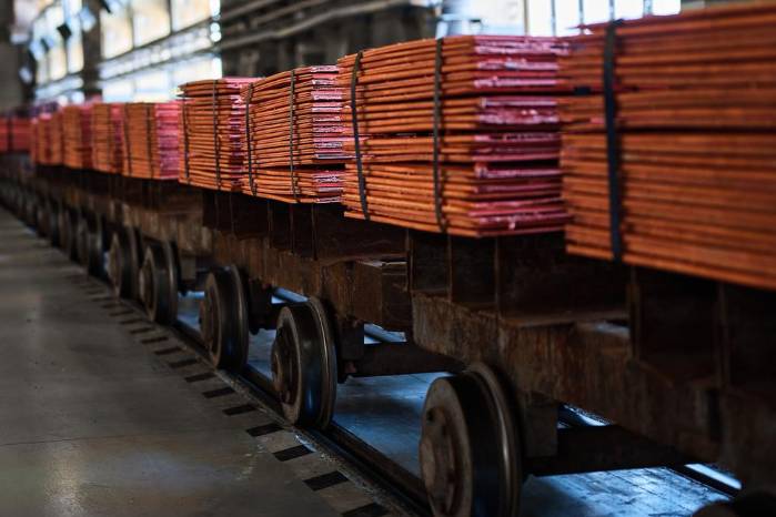Pilas de hojas de cobre atadas con cintas en vagones de ferrocarril en almacén en una planta de refinería metálica. Pilas de hojas de cobre atadas con cintas en vagones de ferrocarril en almacén en una planta de refinería metálica.