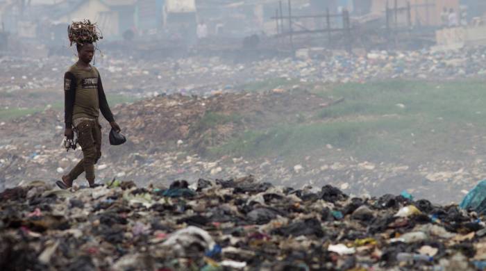 En la imagen de archivo, un hombre transporta cables sobre su cabeza en el vertedero de Agbogbloshie, un barrio de Accra, capital de Ghana, considerado el mayor vertedero de basura electrónica del continente Africano. EFE/A. Carrasco Ragel