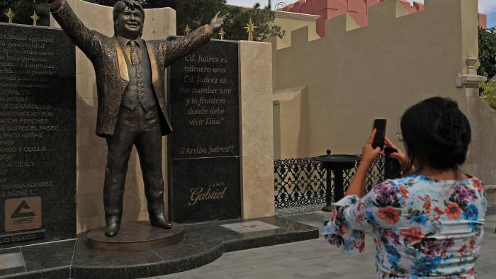 Una mujer toma una fotografía de la estatua del cantautor mexicano Juan Gabriel. Una mujer toma una fotografía de la estatua del cantautor mexicano Juan Gabriel.