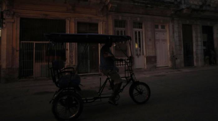 Fotografía de archivo del 26 de marzo de 2024 de un bicitaxi que transita por una calle oscura debido a un apagón, en La Habana, Cuba.
