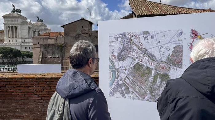 Dos personas supervisan los planos del nuevo recorrido arqueológico que preparará Roma, en Italia, este martes.