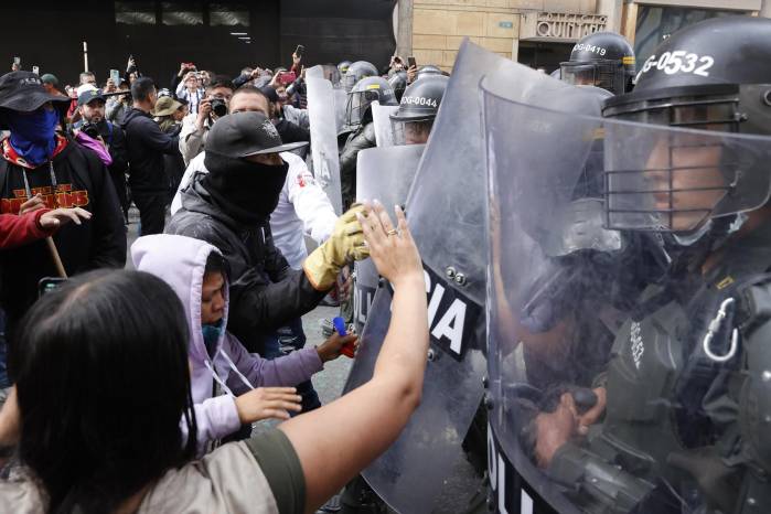 Personas se enfrentan con la Policía durante una protesta hoy en Bogotá. Personas se enfrentan con la Policía durante una protesta hoy en Bogotá.