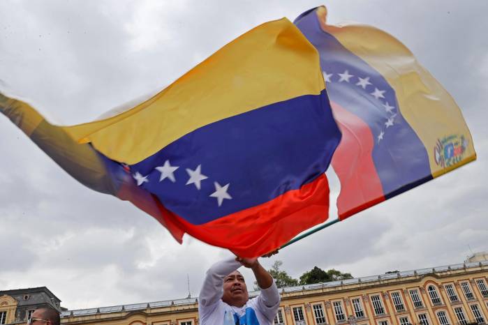 Fotografía de archivo en donde un hombre agita una bandera venezolana. Fotografía de archivo en donde un hombre agita una bandera venezolana.