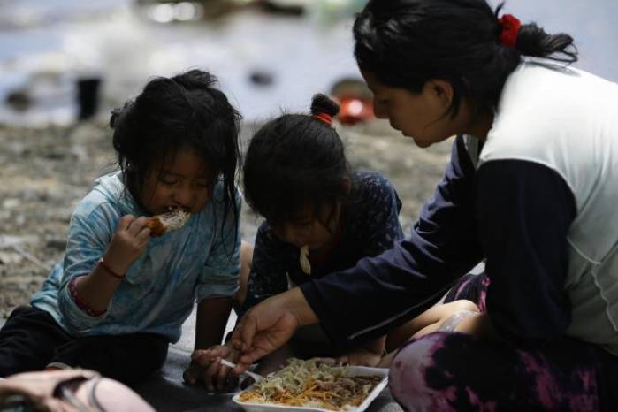 Una migrante ecuatoriana come junto a sus hijas en la selva mientras esperan para ser trasladados en canoa desde la Quebrada León hasta a la comunidad de Bajo Chiquito en Darién. Una migrante ecuatoriana come junto a sus hijas en la selva mientras esperan para ser trasladados en canoa desde la Quebrada León hasta a la comunidad de Bajo Chiquito en Darién.