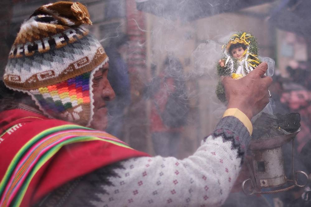 Un sacerdote aimara o 'amauta' sostiene una imagen del niño Jesús durante la misa de Reyes este lunes, en La Paz (Bolivia). Un sacerdote aimara o 'amauta' sostiene una imagen del niño Jesús durante la misa de Reyes este lunes, en La Paz (Bolivia).