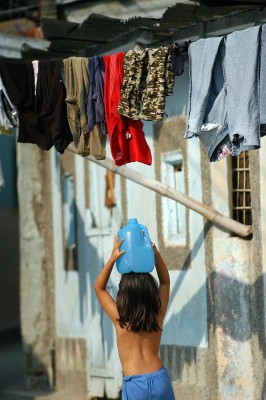 Una niña salvadoreña mientras carga un recipiente con agua a su vivienda, en la afueras de San Salvador (El Salvador). Disfrutar la infancia o terminar los estudios siguen siendo asuntos irrealizables para millones de niñas en Latinoamérica.