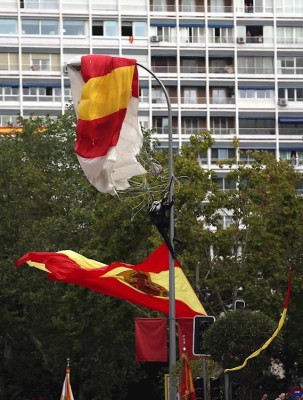 El miembro de la Brigada Paracaidista que descendía portando la bandera de España, en la farola en la que se enganchó momentos antes de tomar tierra en el madrileño Paseo de la Castellana.