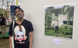 Rafael Arrocha, uno de los curadores de Macroarte, junto a una fotografía de Vega y Patiño.