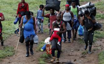 Fotografía de archivo que muestra a migrantes haitianos en su camino hacia Panamá por el Tapón del Darién en Acandi (Colombia).