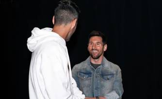 Sergio Busquets (i.) junto con Lionel Messi (d.) en el Kaseya Center para ver a los Miami Heat.