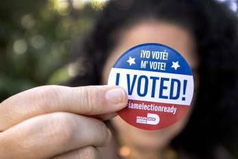 Una persona muestra una calcomanía de Yo voté después de emitir su voto en la biblioteca de Palmetto Bay en la votación anticipada para las elecciones presidenciales estadounidenses de 2024 en Miami.