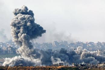 Esta imagen, tomada desde el lado israelí de la frontera con la Franja de Gaza, muestra columnas de humo ascendiendo desde las explosiones sobre los edificios destruidos en el norte de la Franja de Gaza este 14 de enero.